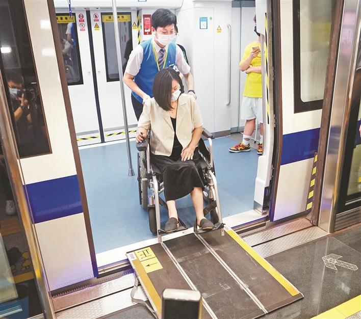 深圳地铁工作人员利用踏板协助坐轮椅的陈女士下地铁.jpg