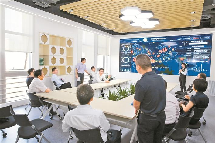 深圳市智慧残联（电召中心）服务平台工作人员向来访人员介绍相关业务。.jpg