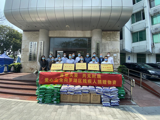 罗湖区残联班子成员和各科室负责人、5家企业代表与部分爱心物资合影.png