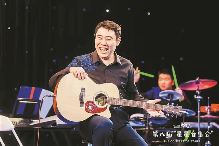 2021年的音乐会上，乐团成员贝贝开心地弹着吉他.jpg