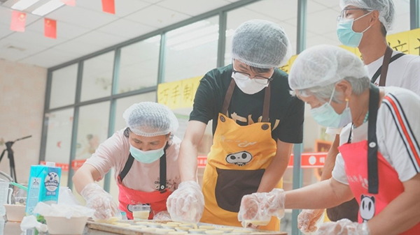 图为实践队员向参加过技能培训的残疾人学习如何制作蛋挞 通讯员 郑瑞基 摄.jpg