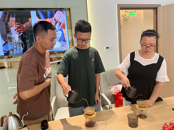 会员认真学习咖啡制作技巧的场景，展现了积极向上的精神面貌