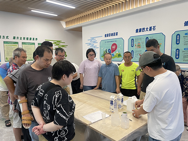 图：专业教师通过分步演示指导残疾人掌握手工制作技能