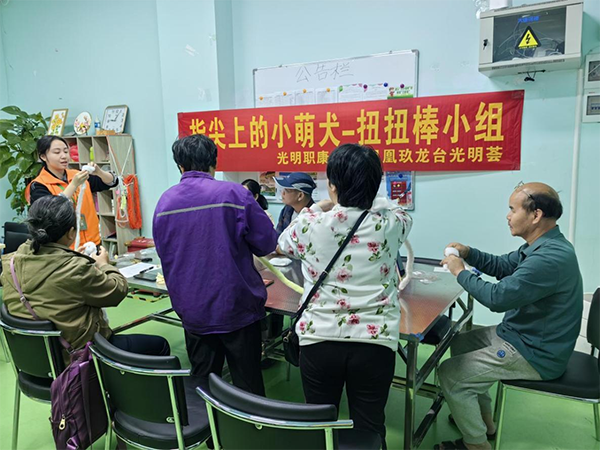 图：手工老师带领残疾人学习手工制作技巧