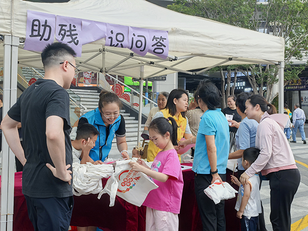图：居民有序排队参与助残知识问答