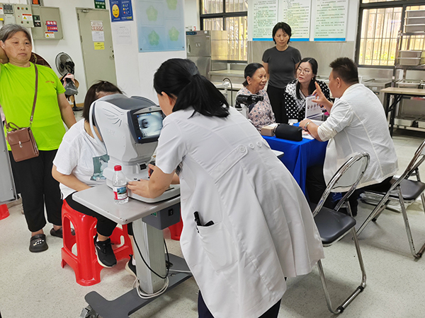 图：居民参加眼部检查现场
