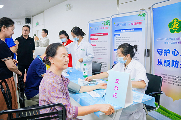 图：医护人员为社区居民进行血压、血糖基础检测