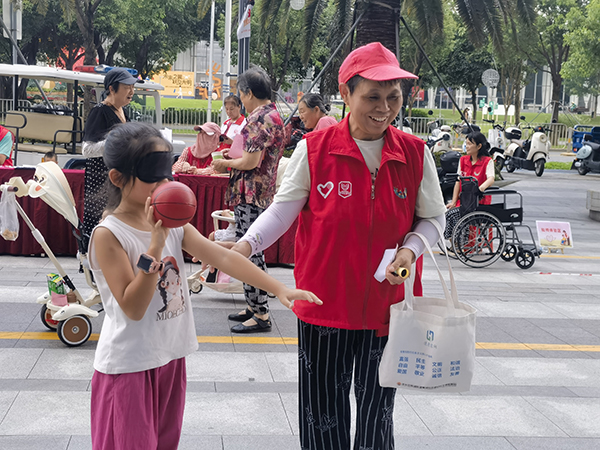 图：居民参与蒙眼投篮，体验视觉受限带来的挑战