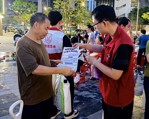 图：志愿者为老年人科普预防残疾核心知识