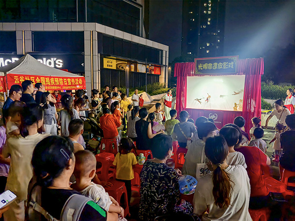 图：居民们认真专注，沉浸于皮影戏演出
