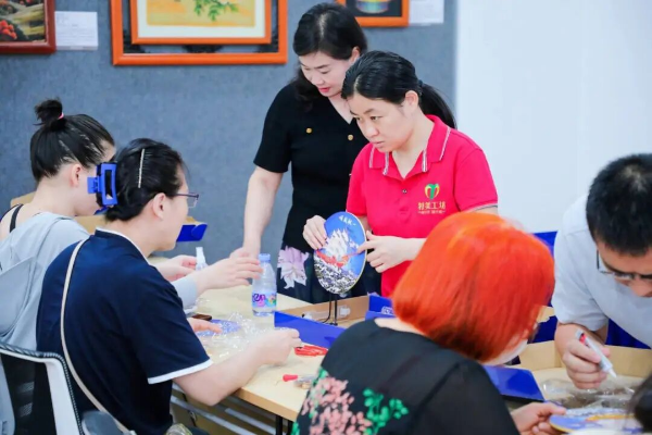 “特美工坊”工匠团队带领居民体验制作景泰蓝珐琅画。受访单位供图.jpeg