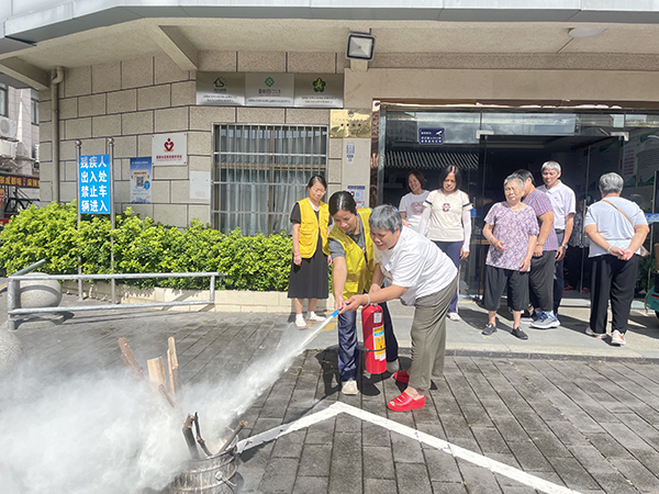 图：楼村日照中心安全员手把手教残疾人家属正确使用灭火器灭火