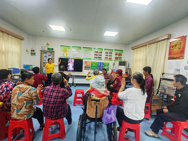 图:工作人员带领残疾人做手指操 图:工作人员带领残疾人做手指操