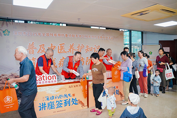 图：党员志愿者为活动参加者发放宣传资料