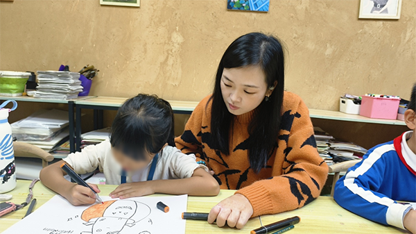 图：冯银妹在美术工作室担任美术老师
