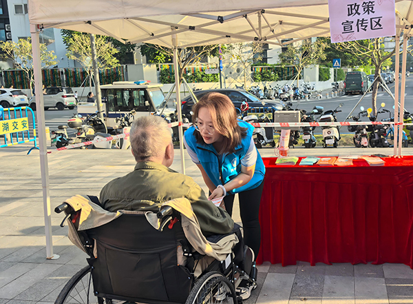 图：“双百”社工向居民介绍政策宣传内容
