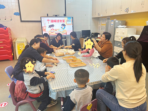 图：花花班的家长和小朋们合作擀饺子皮