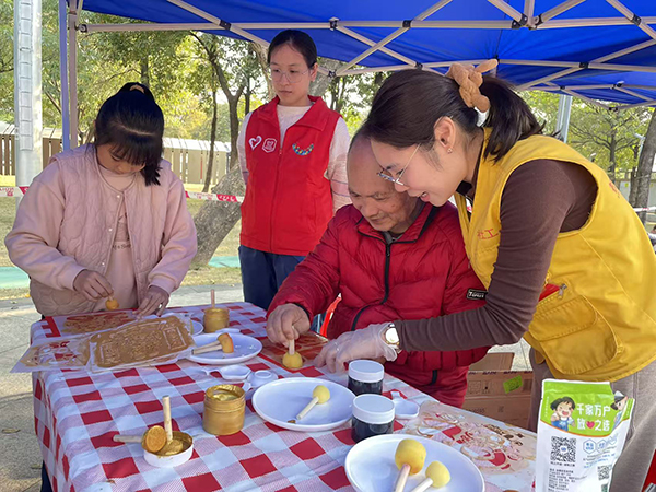 图：工作人员耐心教参与者手工拓福