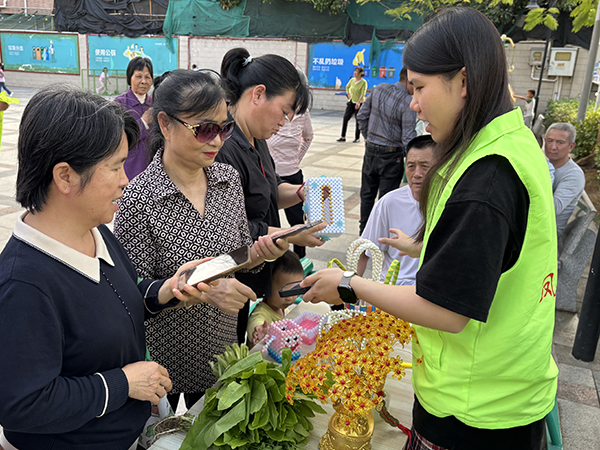 图：社区居民围观蔬菜成果及手工艺品