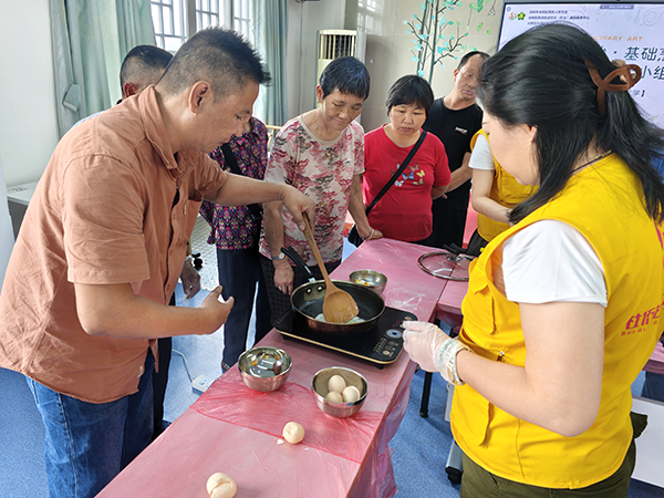 图：残疾人小李正专注地单手翻炒着