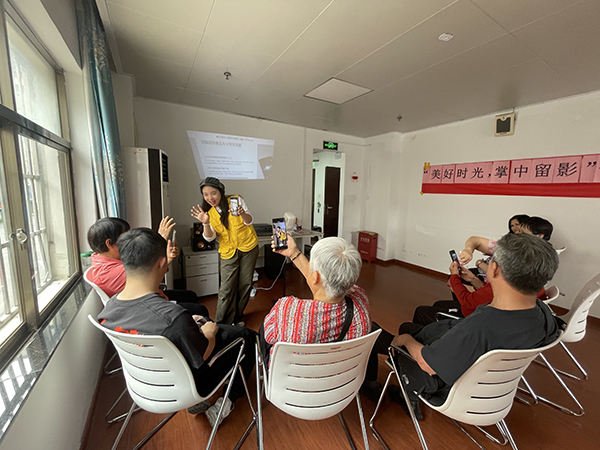 图：社工耐心地讲解手机拍照的基础操作