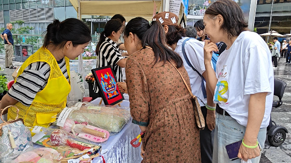 工作人员在罗湖区益田假日广场义卖爱心作品.jpeg
