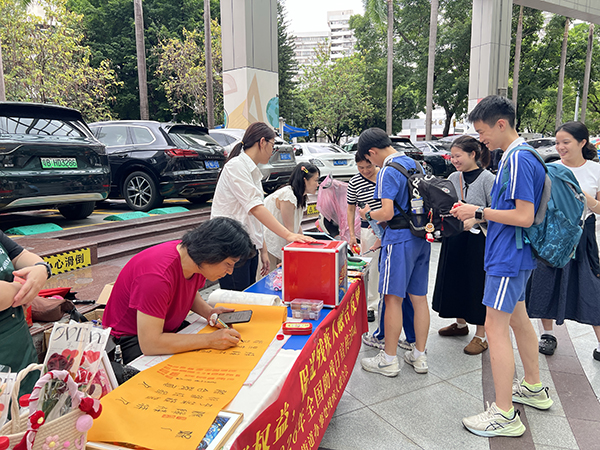 图：书法老师现场题诗为残健相融勾勒出美好愿景