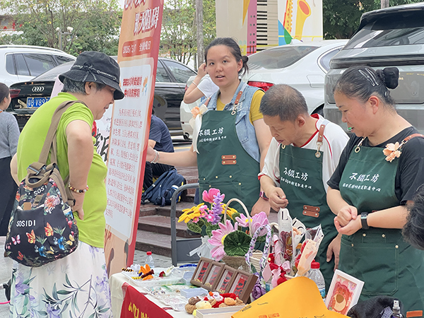 图：义卖摊位居民正在选购手工艺品