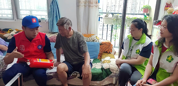 消防员向残疾人家属讲解如何使用消防器材