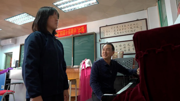 周麒麟正在指导陈琳学音乐