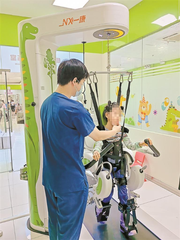 治疗师协助脑瘫患儿进行下肢康复机器人训练