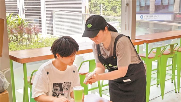店主芸子用手机和顾客交流