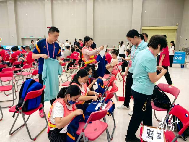 保洁阿姨为深圳队队员缝制名牌