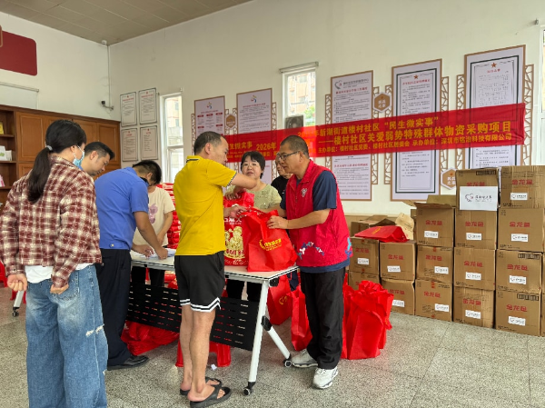 活动现场社区工作人员与志愿者为弱势特殊群众分发物质