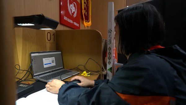 在深圳图书馆，母亲林女士为陈琳整理学习资料