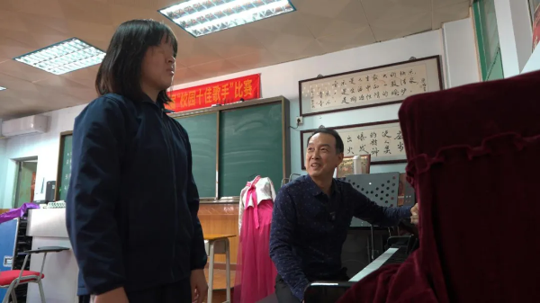 周麒麟正在指导陈琳学音乐