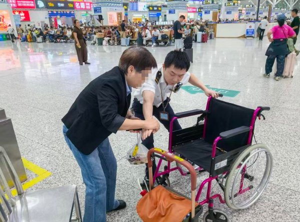 深圳北站安检工作人员使用轮椅靠前帮扶旅客