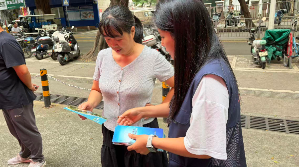 社工向过往居民发放心理健康宣传资料