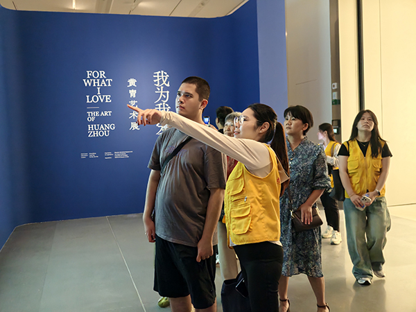 工作人员向残疾人介绍作品